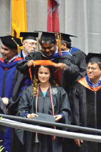 Krishna decorates UNM doctoral student Lilian Casias for her Masters' degree